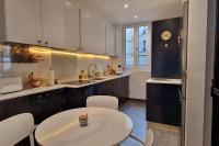 a kitchen with a white table and white chairs at Magnifique appartement de charme au cœur de Paris in Paris