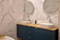 a bathroom with two sinks and two mirrors at Magnifique appartement de charme au cœur de Paris in Paris