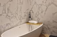 a white bathroom with a tub and a sink at Magnifique appartement de charme au cœur de Paris in Paris