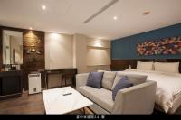 a hotel room with a bed and a couch at P&amp;F Hotel in Taichung