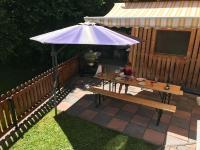 a child sitting at a picnic table under an umbrella at Large 8 Bed Apartment. Perfect Location. in Stuhlfelden
