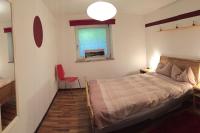 a bedroom with a bed and a window and a red chair at Large 8 Bed Apartment. Perfect Location. in Stuhlfelden