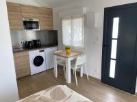 a kitchen with a table and a washing machine at Studio Les Oliviers in Noisy-le-Grand