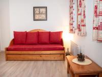 a red couch in a living room with a table at Appartement Vignec, 2 pièces, 6 personnes - FR-1-504-176 in Vignec