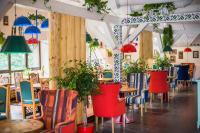 een restaurant met kleurrijke stoelen en tafels en potplanten bij Girska Tysa Health Resort in Kvasy
