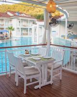 uma mesa branca e cadeiras num deque com piscina em Mozaik Hotel em Oludeniz