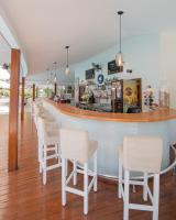 um bar com cadeiras brancas e um balcão em Mozaik Hotel em Oludeniz