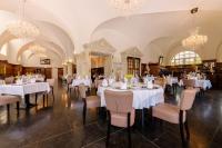 a dining room with white tables and chairs and chandeliers at Schloss Purschenstein in Neuhausen
