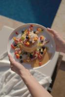 a woman holding a plate with a dessert on it at AlaBora Hotel in Alacati