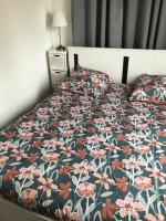 a bedroom with a bed with a floral bedspread at La clef Sithieu in Saint-Omer