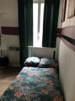 a bed in a room with a window and a bedspread at La clef Sithieu in Saint-Omer