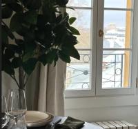 a table with a plate and a vase with a plant at Amazing view on the Versailles Palace - Paris 15min in Versailles
