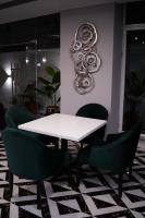 uma mesa branca e cadeiras verdes num quarto em Faletti’s Grand MM Alam Road em Lahore