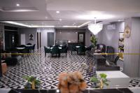 um lobby com um restaurante com mesas e cadeiras em Faletti’s Grand MM Alam Road em Lahore