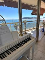 a piano sitting on a balcony with a view of the ocean at Appartement panoramique sur mer in Toulon