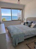 a bedroom with a bed with a view of the ocean at Appartement panoramique sur mer in Toulon
