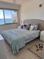 a bedroom with a bed with a view of the ocean at Appartement panoramique sur mer in Toulon