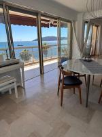 a living room with a table and a view of the ocean at Appartement panoramique sur mer in Toulon