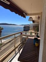 a balcony with a wooden table and chairs and the ocean at Appartement panoramique sur mer in Toulon