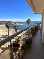 a balcony with a view of a beach with palm trees at Appartement panoramique sur mer in Toulon