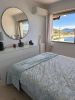 a bedroom with a bed and a mirror and a window at Appartement panoramique sur mer in Toulon