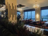 Un restaurante con mesas y sillas y grandes ventanales. en Holiday Inn Sydney - Waterfront by IHG, en Sydney