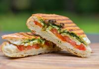 un panino tagliato a metà su un tagliere di legno di Capung Asri Eco Luxury Resort with Private Pool Villas a Bedahulu