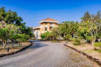 a house on a road with trees in front at Southern Sun Homestay North in Kenting