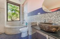 a bathroom with a sink and a tub and a toilet at Southern Sun Homestay North in Kenting