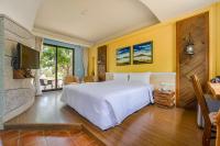 a bedroom with a white bed and a flat screen tv at Southern Sun Homestay North in Kenting