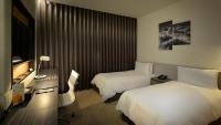 a hotel room with two beds and a television at Golden Tulip Glory Fine Hotel in Tainan