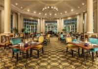 Un restaurante con mesas y sillas y una lámpara de araña. en Hemingways Hotel, en East London