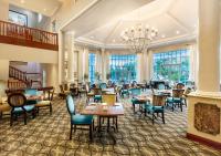 Un restaurante con mesas y sillas y una lámpara de araña. en Hemingways Hotel, en East London