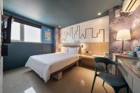 a bedroom with a bed and a desk with a chair at S&amp;E Hotel in Tainan