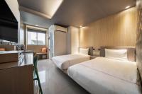 a hotel room with two beds and a kitchen at S&amp;E Hotel in Tainan