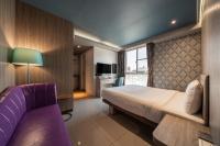a hotel room with a bed and a purple couch at S&amp;E Hotel in Tainan