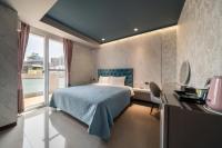 a bedroom with a bed and a desk and a window at S&amp;E Hotel in Tainan