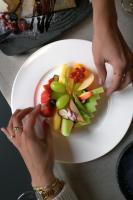 a person reaching for a plate of fruit and vegetables at Hotel A&#39;mare in Zadar