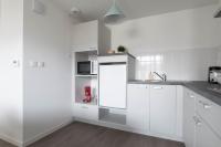 a white kitchen with white cabinets and a microwave at Elodie - T2 proche gare in Le Mans