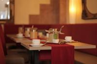 a row of tables with cups and saucers at Hotel Zur Sonne in Waren