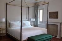 a bedroom with a four poster bed with a green stool at Violino d&#39;Oro Venezia in Venice