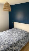 a bedroom with a bed with a blue wall at Appartement lumineux de 60m2 in Guer