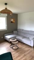 a living room with a couch and a table at Appartement lumineux de 60m2 in Guer