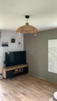 a living room with a flat screen tv and a table at Appartement lumineux de 60m2 in Guer