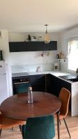 a kitchen with a wooden table and some chairs at Appartement lumineux de 60m2 in Guer