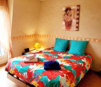 1 dormitorio con 1 cama con un edredón colorido en L&#39; Appart BELLE VUE GARE ET CENTRE 10 mn à pied GARAGE GRATUIT, en Colmar