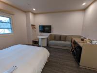 a hotel room with a bed and a couch at Kindness Hotel - Tainan Minsheng in Tainan