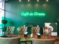 a table with chairs and a green sign on a wall at The Clover Hotel Angeles City in Angeles