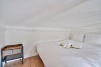 a white bed with two stuffed animals on top of it at GuestReady - Beautiful Apt near Paris Zoo in Paris