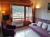 a living room with a purple couch and a window at Appartement Le Grand-Bornand, 3 pièces, 6 personnes - FR-1-241-61 in Le Grand-Bornand